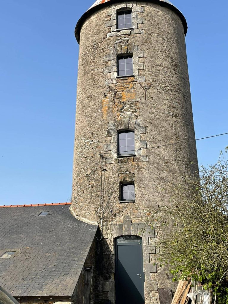 Installation de fenêtres sur mesure en aluminium noir dans un ancien moulin rénové à proximité de Carquefou.