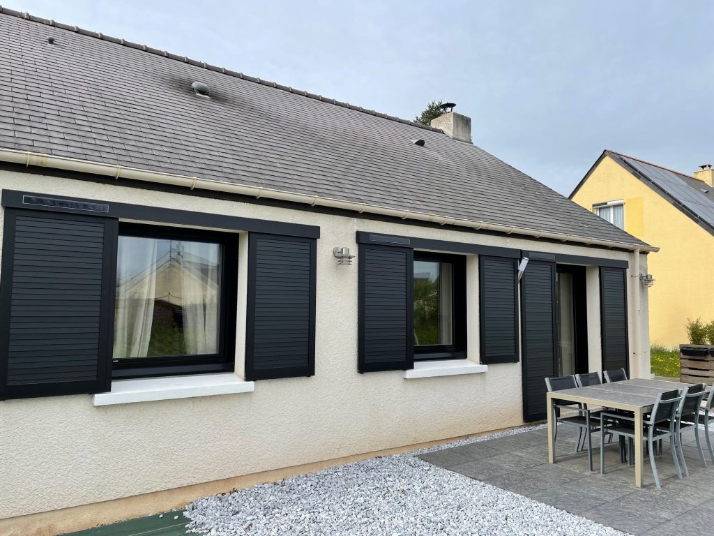 Volets coulissants en aluminium noir installés sur une maison contemporaine, par Bonno Ouvertures.
