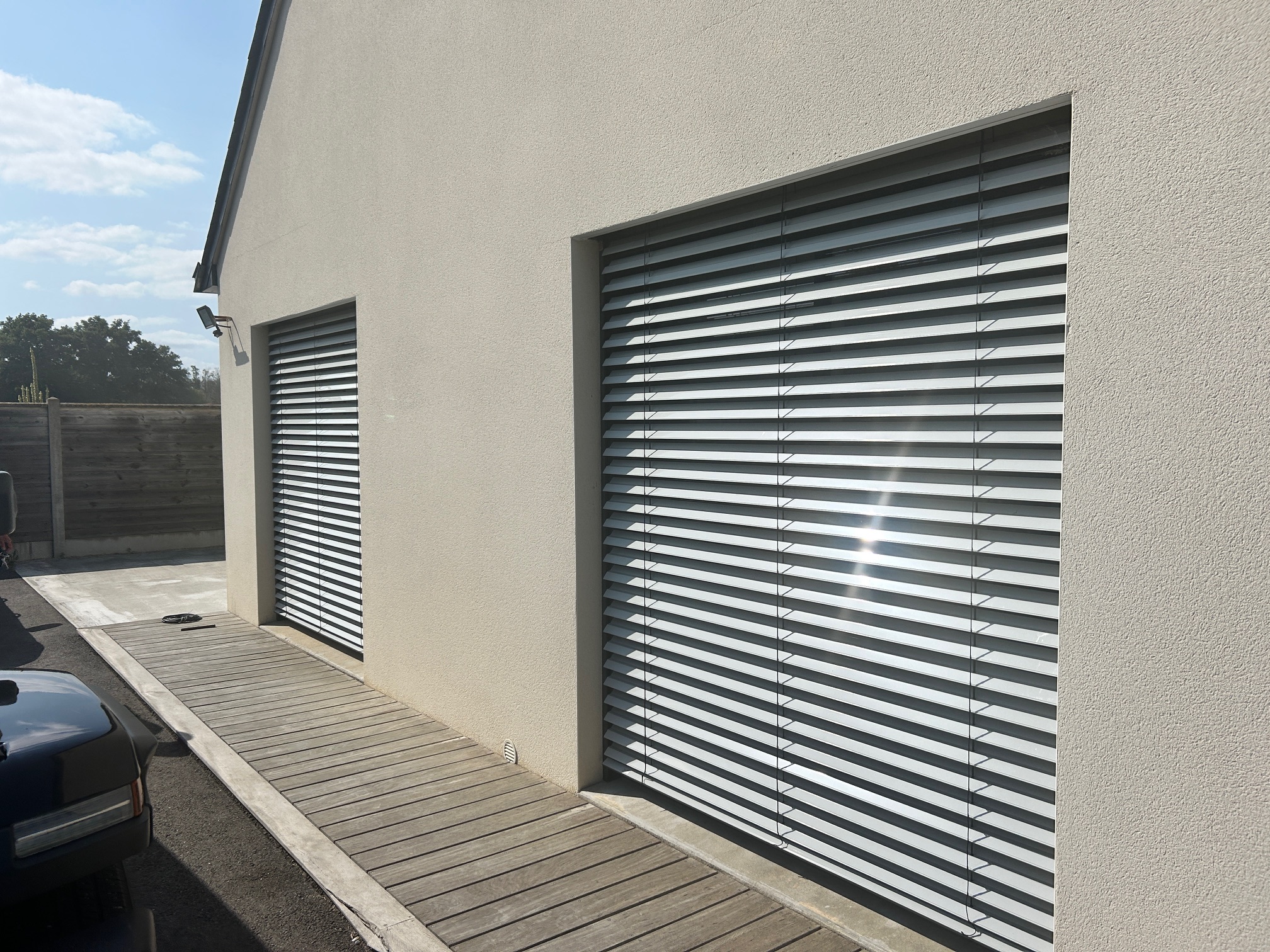 Volets à lames orientables (BSO) en aluminium installés sur deux grandes baies vitrées, par Bonno Ouvertures.