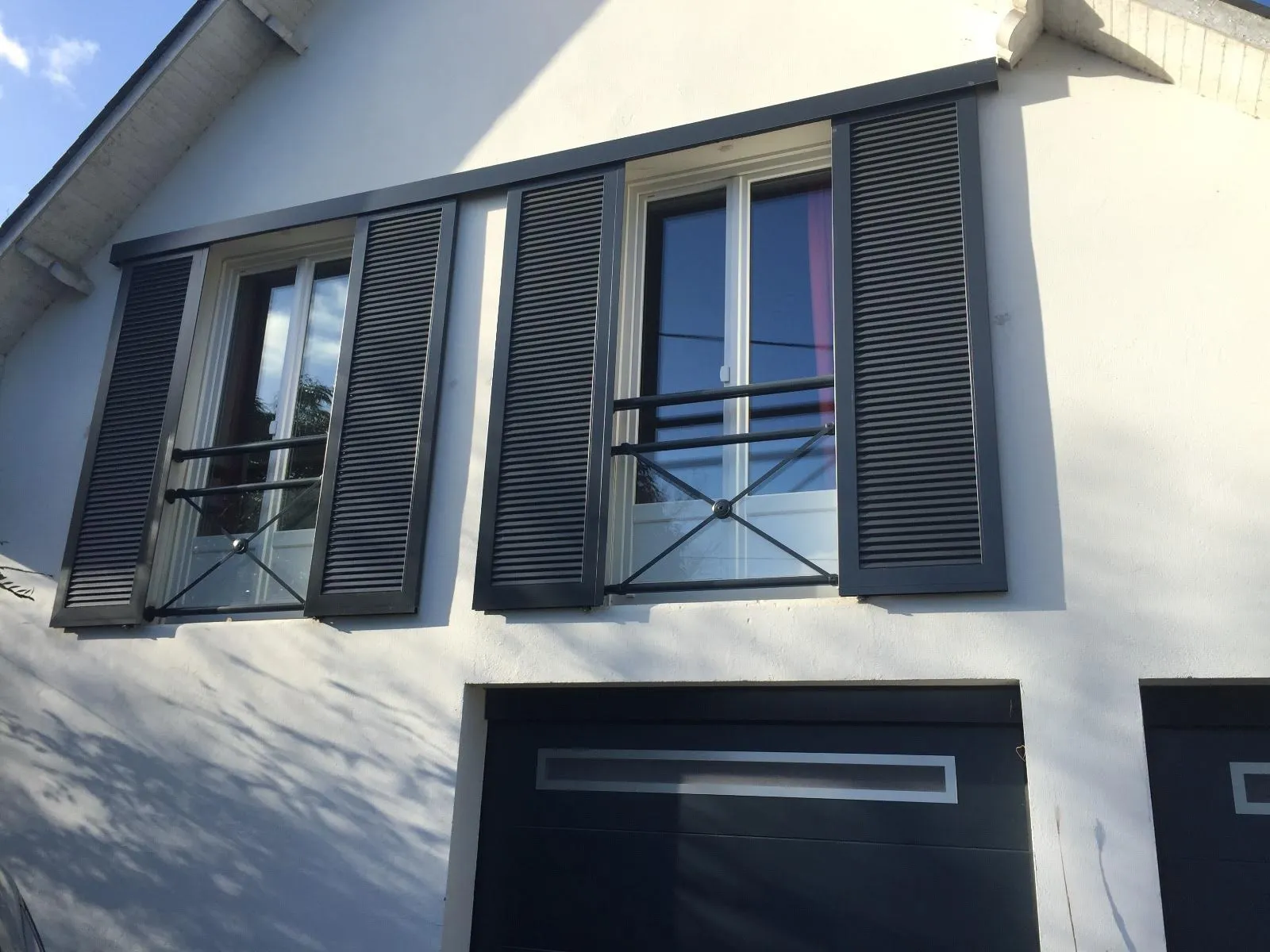 Volets battants aluminium gris anthracite à lames ajourées installés sur fenêtres à l’étage d’une maison en Loire-Atlantique